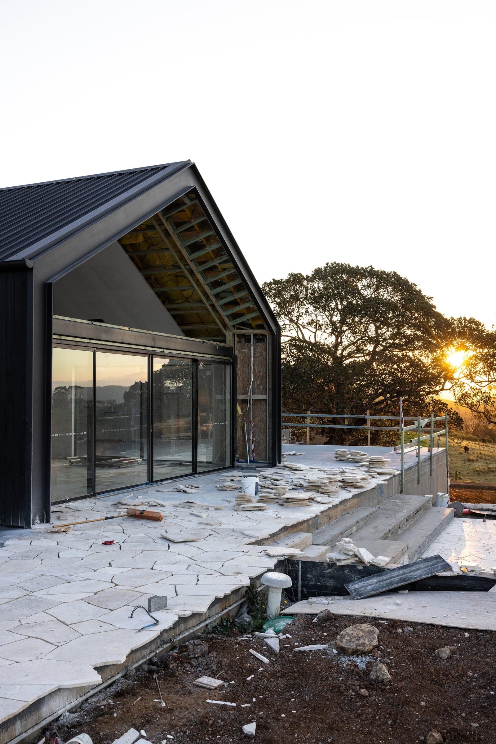 Glazed gable end of a Halls Road pavilion, with stone paving being laid